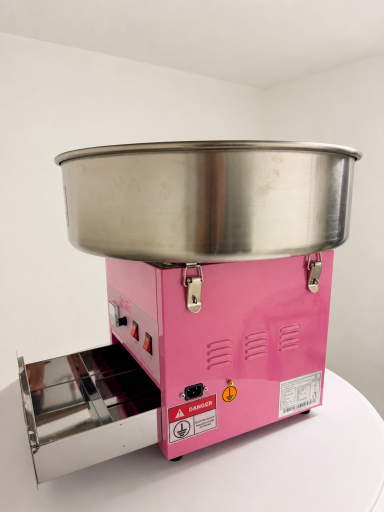 Rosa Zuckerwattemaschine mit metallem Behälter, auf einem weißen Tisch.